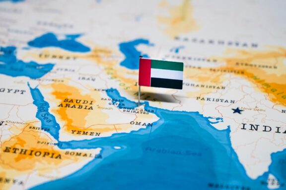 UAE's location in the Southeast of the Arabian Peninsula marked by a pin of its national flag