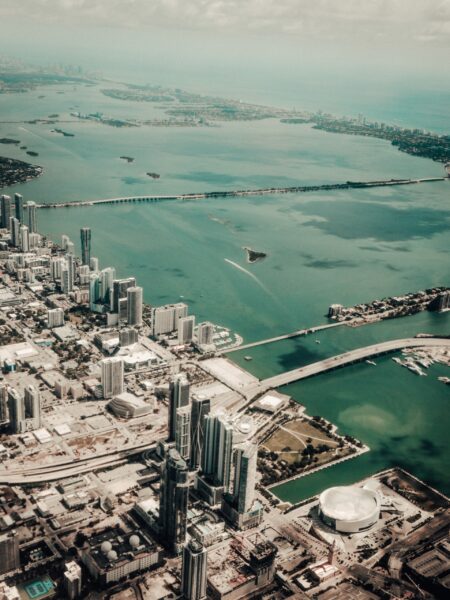 Aerial shot of Fort Lauderdale, Florida, displays city skyline, high-rise buildings near the coast, and bridges over waterways.