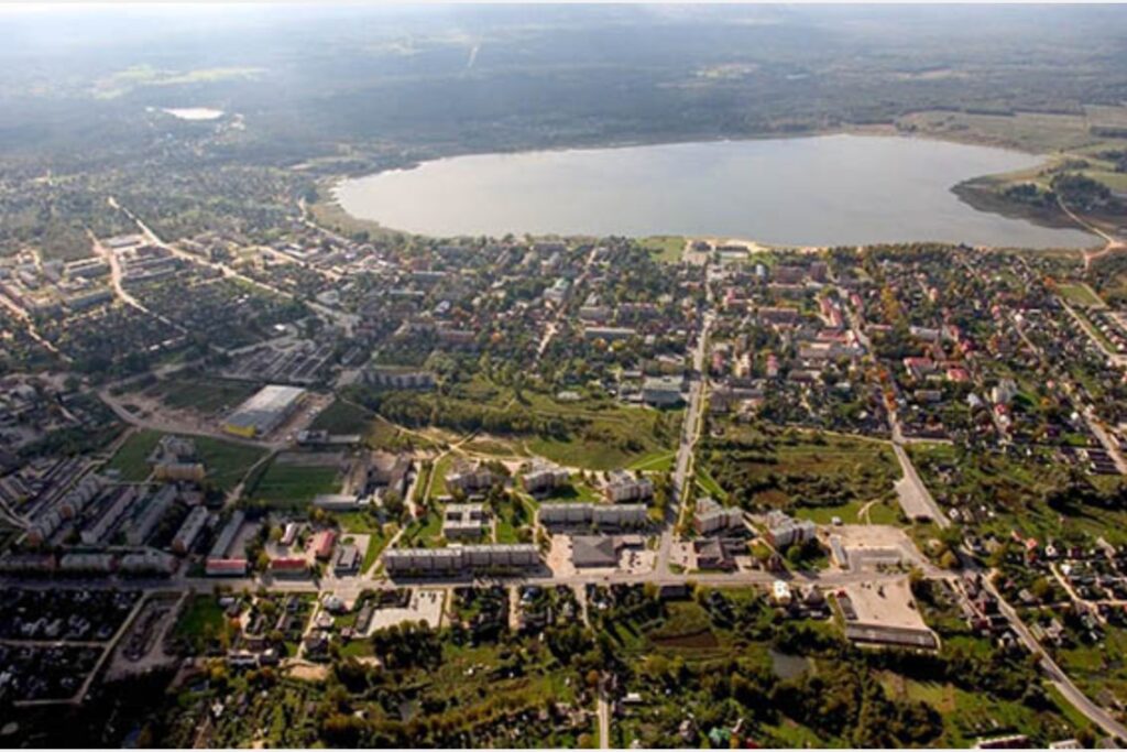 Aerial view of Võru, Estonia displays residential, commercial zones, intersecting roads, greenery, and a nearby lake.