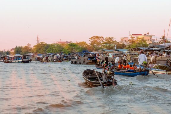 A bustling river scene with boats at sunset in Can Tho, Vietnam.