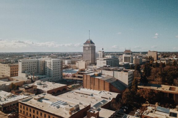 Aerial View of Downtown Fresno, California Aerial view of downtown Fresno, California, with a mix of mid-rise buildings under a clear sky.