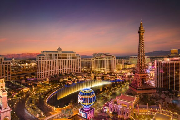 Twilight Skyline of Las Vegas with Iconic Hotels and Attractions Aerial view of Las Vegas, Nevada at twilight with illuminated buildings and a replica of the Eiffel Tower visible.