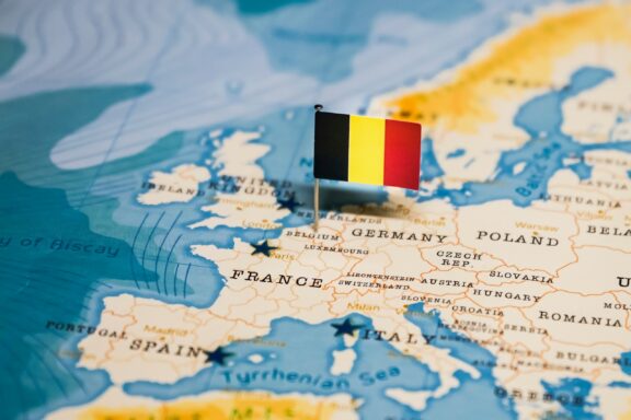 Flag of Belgium pointing at the location of Belgium on the European map