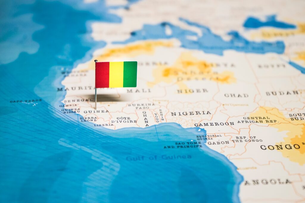 Guinea's location in West Africa marked by a flag pin of its national flag