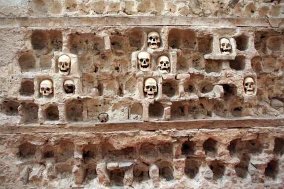 A wall with multiple human skulls embedded within niches, located at Skull Tower in Niš, Serbia.