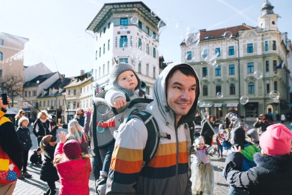 People celebrate Pust (Carnival). Father with child at old center in Ljubljana, Slovenia.