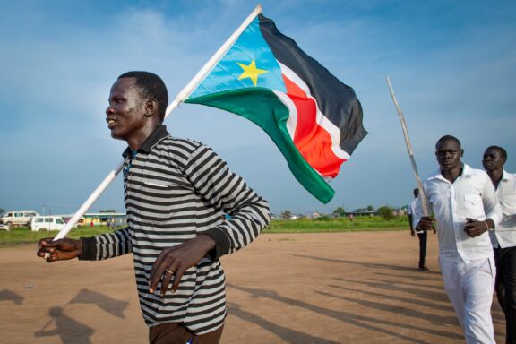 A man holding the South Sudanese flag in Juba.