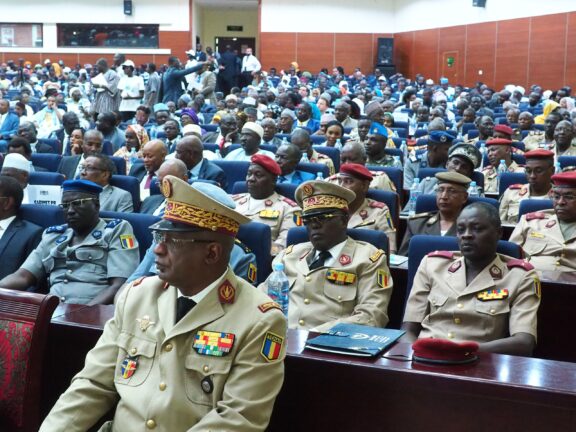 A group of people, including several in military uniforms, sitting in a conference hall or auditorium in N'Djamena, Chad, Africa.