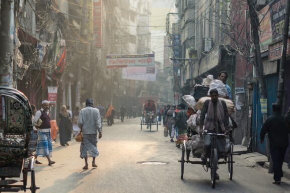 Locals commuting on Rickshaws in the streets of Dhaka