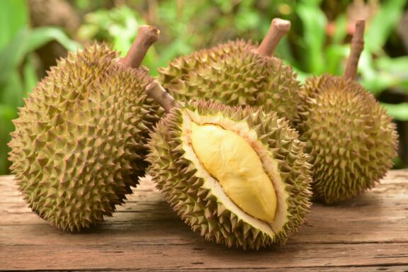 Whole and Opened Durian Fruit on Wooden Surface Durian fruit