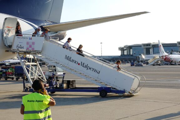 Passengers get off the plane at malpensa airport milan italy