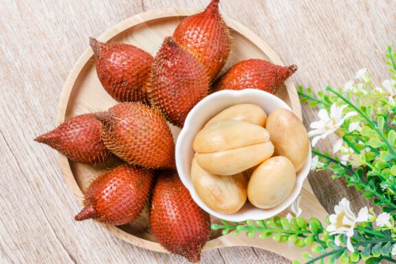 Bowl of Snake Fruit on Wooden Table Salak palm waive or snake fruit in wooden dish