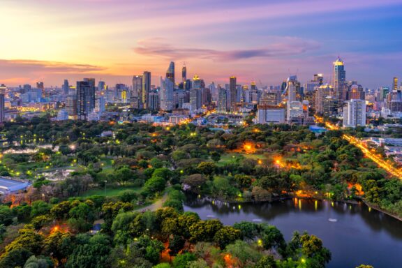 Sunset scence of modern office buildings and condominium in Bangkok city downtown with sunset sky and clouds at Bangkok , Thailand. Lumpini park