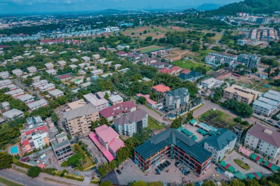 Drone Shot of an African Housing Estate in a City Centre in Abuja, Nigeria overlaps a busy Highway.