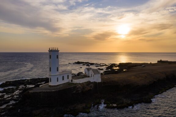 Aerial View of Coastal Lighthouse at Sunset Aerial view of Praia Dona Maria Pia lighthouse
