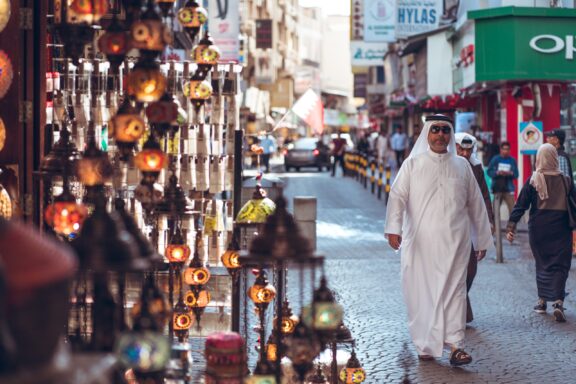 Bahrain city: local muslim walking in the street market.