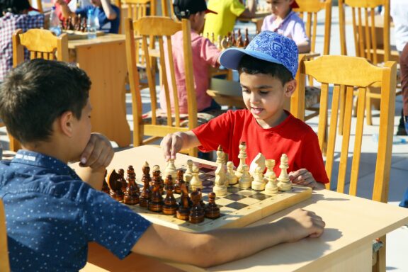 Children play chess a park on a sunny day in Baku, Azerbaijan.