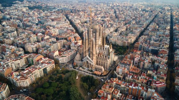 Aerial drone view of Barcelona, Spain. Blocks with multiple residential buildings and Sagrada Familia.