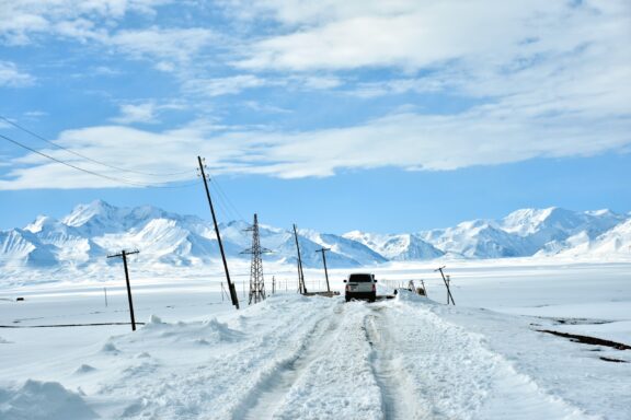 Off road jeep Toyota Land cruiser on a deep snow, traveling across the border from Kyrgyzstan to Tajikistan.