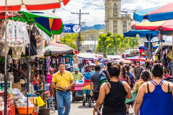 Bustling Street Market with Colorful Umbrellas and Shoppers Calle Poniente market in San Salvador