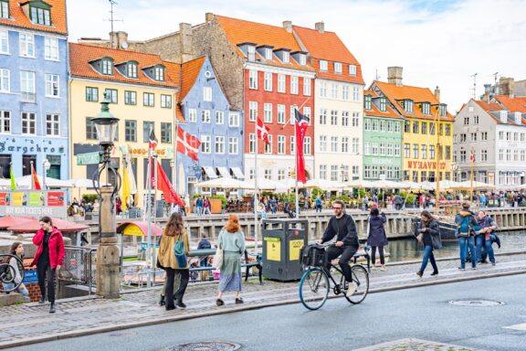 Copenhagen Nyhavn Canal with Colorful Buildings and People People commuting in the Nyvahn district in Copenhagen