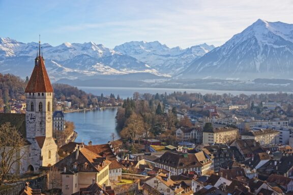 Panorama of City Church and Town of Thun with Alps and Thunersee. Thun is a city in the canton of Bern in Switzerland, where the Aare river flows out of Lake Thun. There is a view of Bernese Alps.