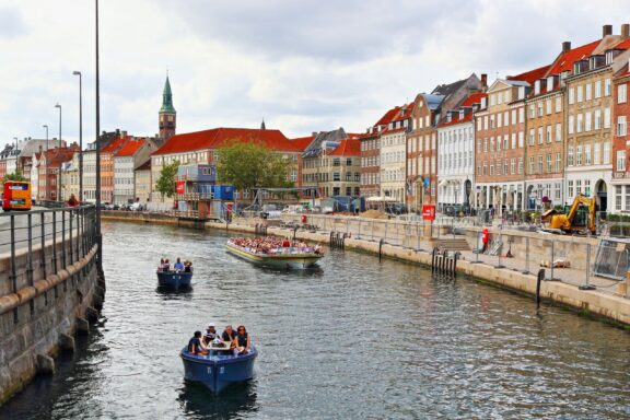 Copenhagen Canal Tour with Boats and Historic Buildings Tourists enjoying a canal tour in Copenhagen