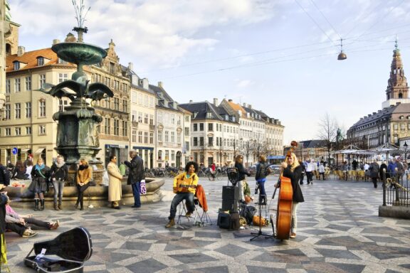 Street Musicians Performing in a Bustling Copenhagen Square Musicians gather near the Stork Fountain in the center of Copenhagen, Denmark.