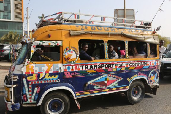 Colorfully Decorated Public Transport Bus with Passengers in Dakar, Senegal A small, painted bus in Dakar, Senegal.