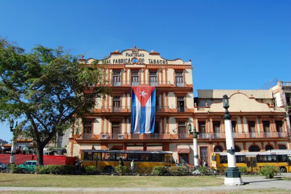 Partagas Cigar Factory with Cuban Flag Partagás Cigar Factory in Havana, Cuba
