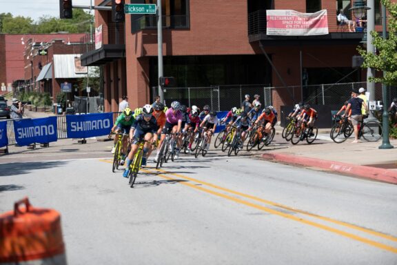 Cyclists Competing in a Road Race Event on a Sunny Day Cyclists round a corner in Fayetteville, Arkansas during the annual Joe Martin Stage Race.