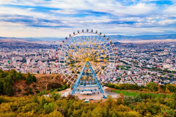 Ferris Wheel Overlooking Cityscape The Ferris Wheel is situated near the Mtatsminda Park