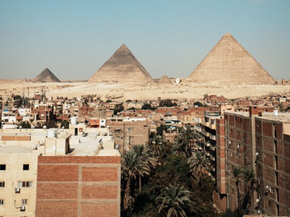 Giza Pyramids Rising Above Urban Landscape Giza downtown with view of the pyramids in egypt africa