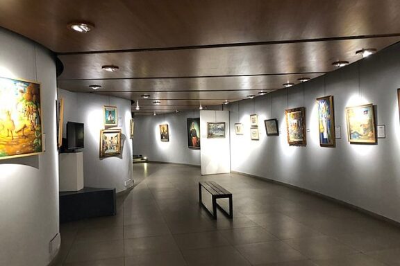 Art Gallery Interior with Paintings and Bench Inside the Pantheon Museum of Haiti in Port-au-Prince