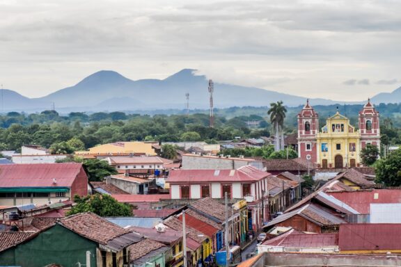 Colonial Architecture and Volcanoes in León, Nicaragua Skyline of Leon, a city in Western Nicaragua, with historic Spanish colonial churches and secular buildings, viewed from the roof of Leon Cathedral, the Basilica of the Assumption.