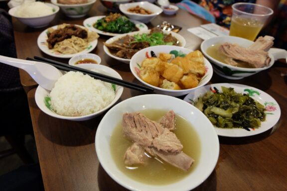 A table full of many local food dishes in Singapore. 