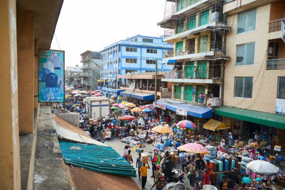 Bustling Street Market with Colorful Umbrellas Crowded streets in the Makola Market in Accra