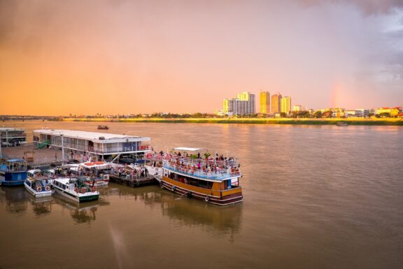 Sunset over Mekong River with Boats in Phnom Penh Tourist boats on Mekong River, Phnom Penh