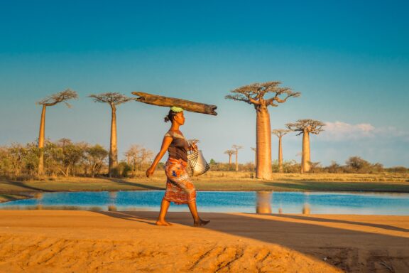 A woman balances a log on her head in Morondova, Madagascar.