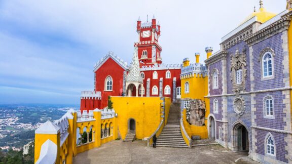 Colorful Pena Palace Against a Cloudy Sky in Sintra, Portugal The colorful Pena Palace can be seen in Portugal.