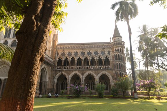 An ornate building stands over a lawn at the University of Mumbai.