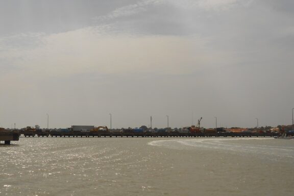 Coastal View of Porto Pidjiguiti Under Overcast Sky The Port of Bissau, the primary entry point for imports into Guinea-Bissau