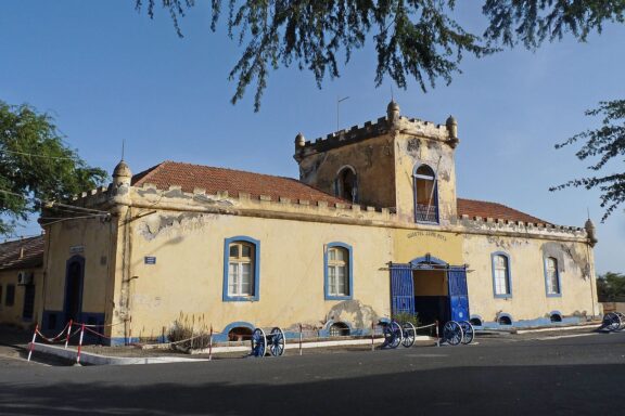 Old Yellow Building with Blue Doors and Bicycles Parked Outside Quartel jaime mota