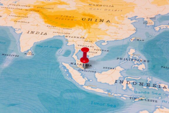 A red pin shows the location of Singapore on the world map.