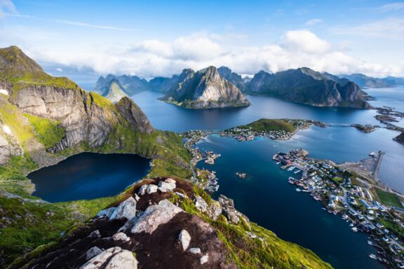 Breathtaking Aerial View of Reine Village and Surrounding Mountains in Lofoten, Norway A view of mountains and sea from the Lofoten archipelago in Norway, one of the top English speaking countries in Europe.
