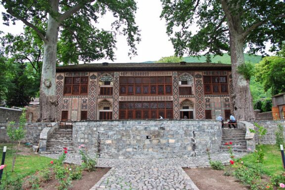 The Khan's Palace stands between trees in Sheki, Azerbaijan.