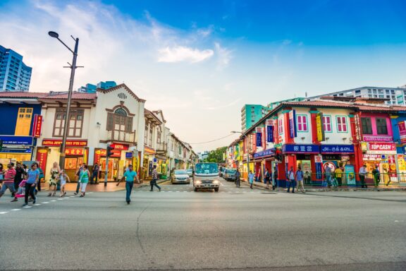 Vibrant Street Scene in Little India, Singapore with Colorful Buildings and Pedestrians People walk across a colorful intersection in Singapore's Little India district.