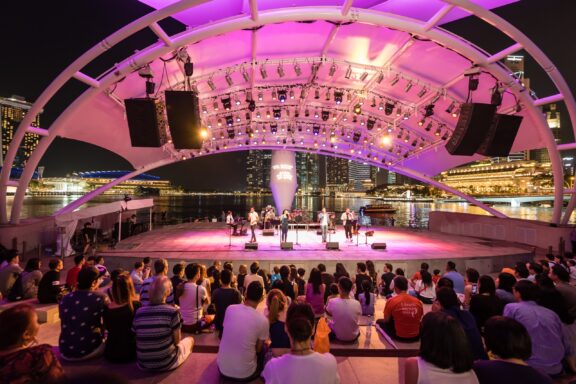 Outdoor Concert at a Waterfront Pavilion in Singapore Musicians perform on a stage at Marina Bay in Singapore.