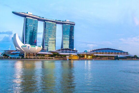 Marina Bay Sands Resort and ArtScience Museum at Dusk in Singapore The Marina Bay Sands Hotel in Singapore can be seen towering over the water.