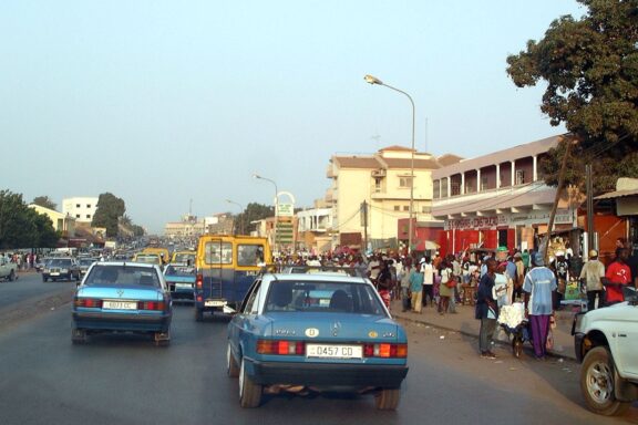 Bustling Street Scene with Cars and Pedestrians Crowds and street scenes in Bissau